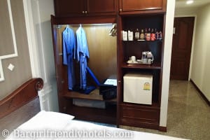Majestic Suites Hotel closet on side of bed with fridge