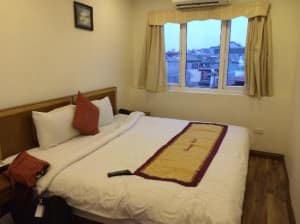 Charming Hotel Hanoi bedroom with small window