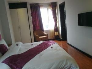 Golden Sun Suites Hotel Hanoi bedroom with flatscreen tv on wall