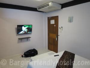 The Yorkshire Hotel view from bed corner with door entrance and LCD TV on wall