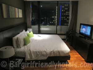 Bedroom wirth TV and view over Bangkok at in the Fraser Suites Sukhumvit Serviced of the Apartment One-Bedroom Deluxe room