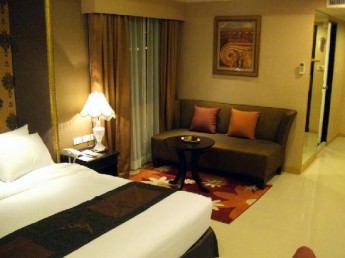 FuramaXclusive Sukhumvit deluxe room with couch and bed
