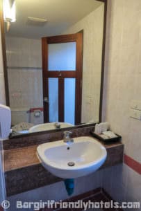 bathroom-sink-and-mirror-found-in-deluxe-studio-of-poppa-palace-hotel